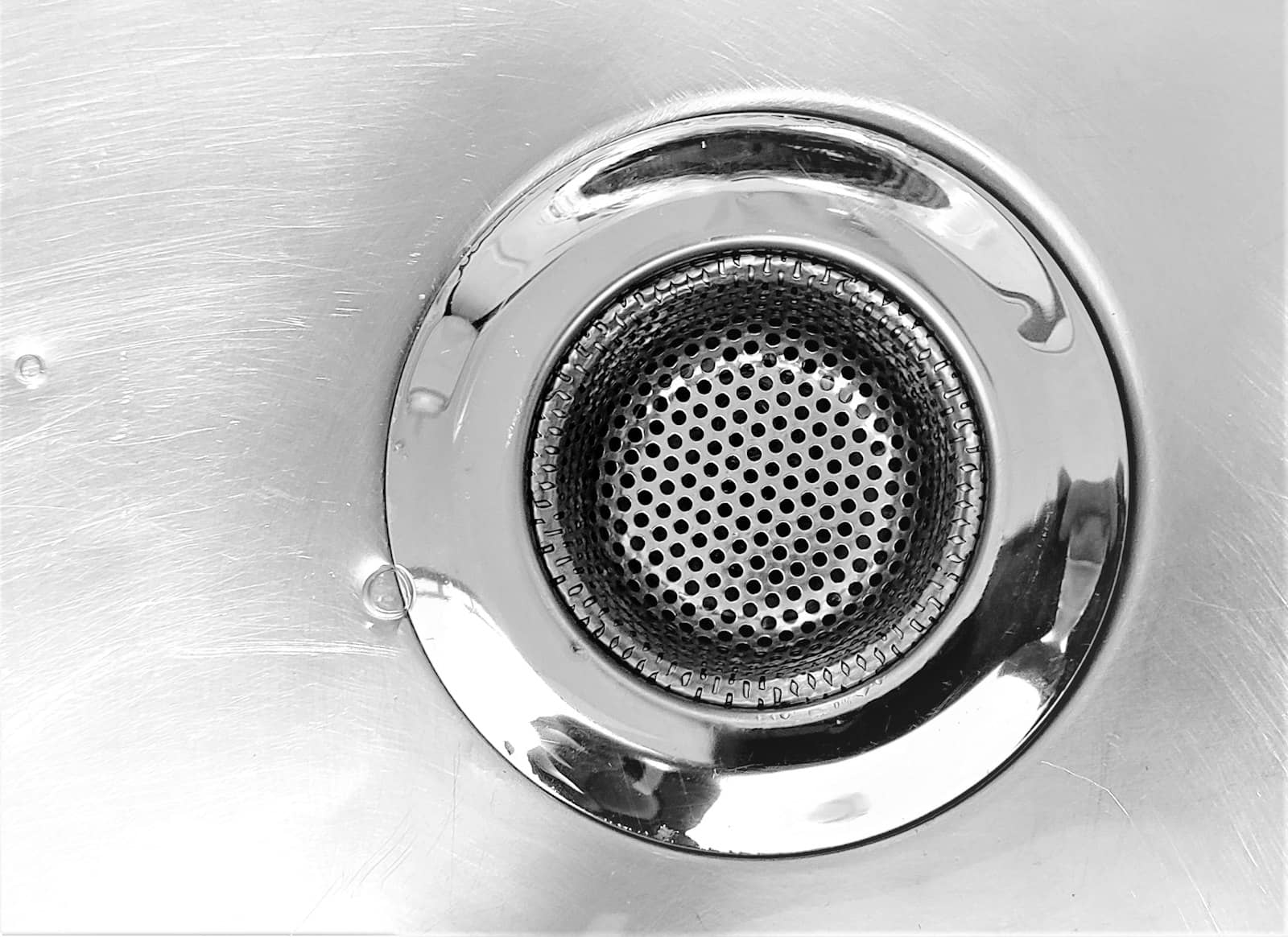 Close-up of a stainless steel sink drain and strainer basket